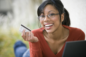 Young woman using credit card to shop online